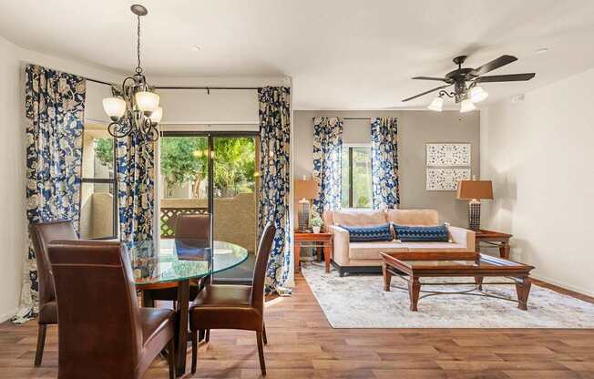 A living room with a glass table and chairs.