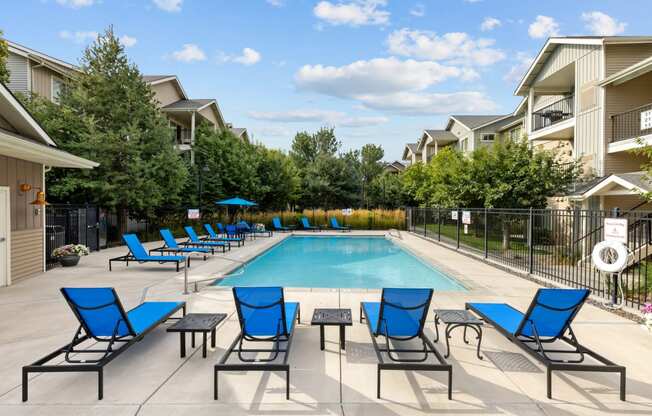 our apartments have a swimming pool with blue chairs