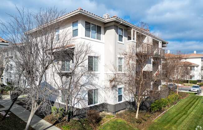 A large white building with a red roof and a tree in front at Cornerstone at Gale Ranch Apartments, San Ramon, CA, 94582