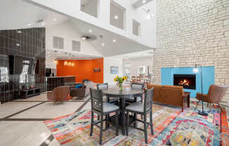A modern living room with a brick wall and a fireplace.