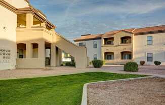 A row of houses with a green lawn in front.