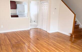 A room with wooden flooring and a staircase.