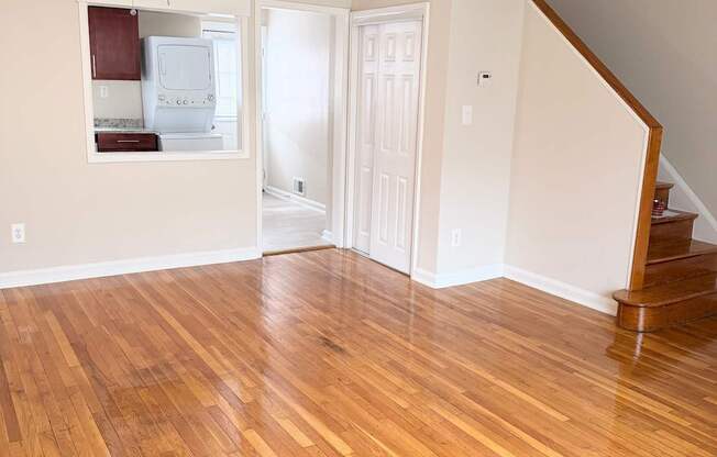 A room with wooden flooring and a staircase.
