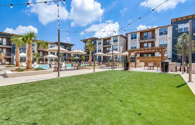 A sunny day at a grassy courtyard with a building in the background.
