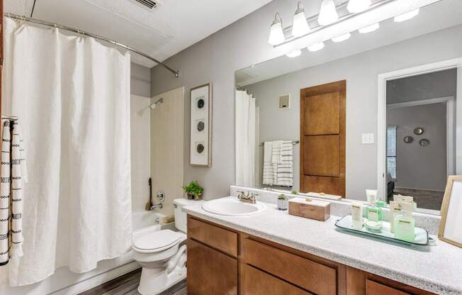 A bathroom with a white toilet, a white sink, and a white shower curtain.