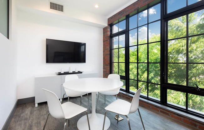 a meeting room with a table and chairs and a large window