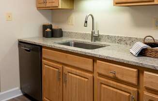 A kitchen with wooden cabinets and a granite countertop.
