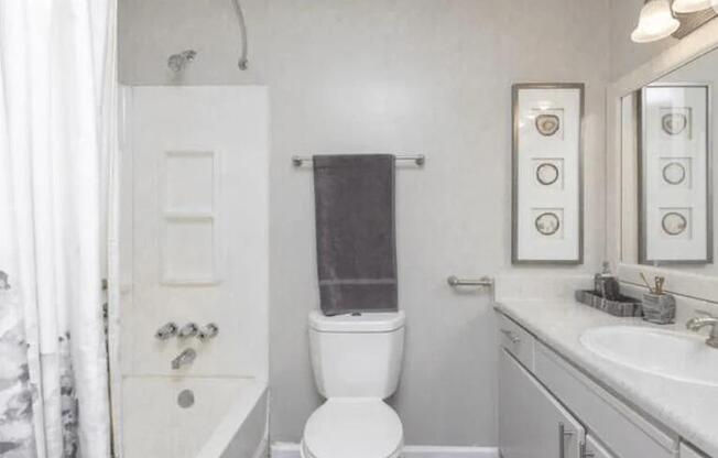 a white bathroom with a toilet and a sink at The Sapphire, Decatur, GA, 30035