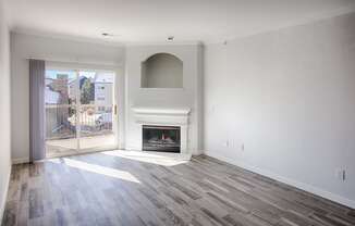 living room with grey wood style floors, fireplace and balcony