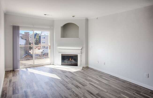 living room with grey wood style floors, fireplace and balcony