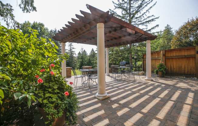 a patio with a pergola and a table and chairs