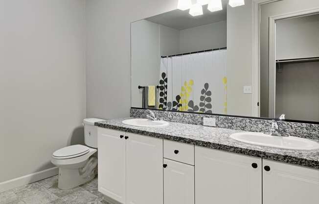 a white bathroom with two sinks and a toilet