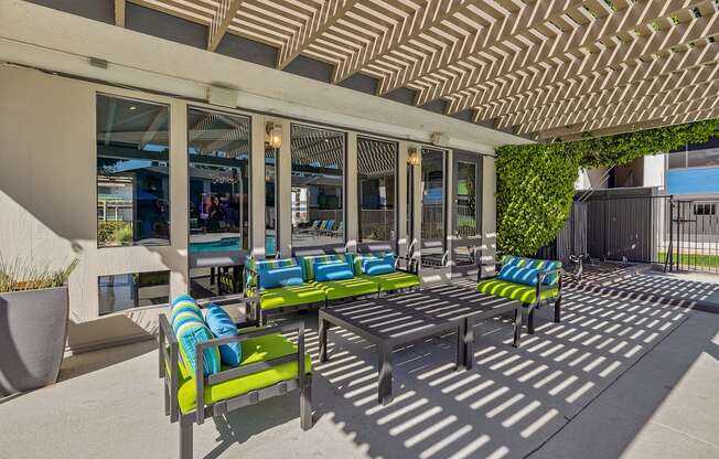 a patio with blue and green chairs and a table