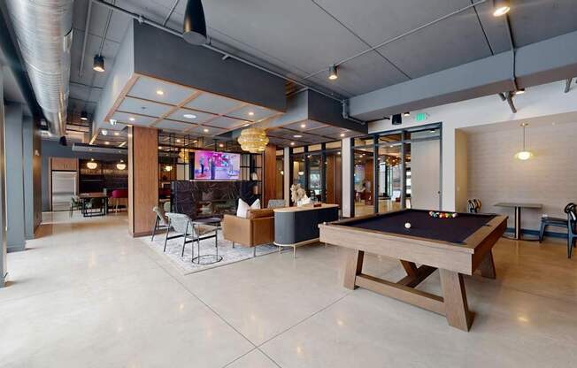 A room with a pool table and a television.