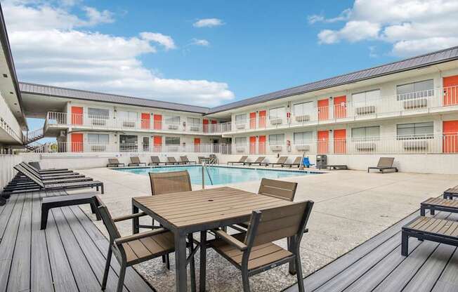 A wooden table and chairs are set up on a wooden deck.
