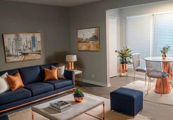 A living room with a blue sofa, a coffee table, and two chairs.