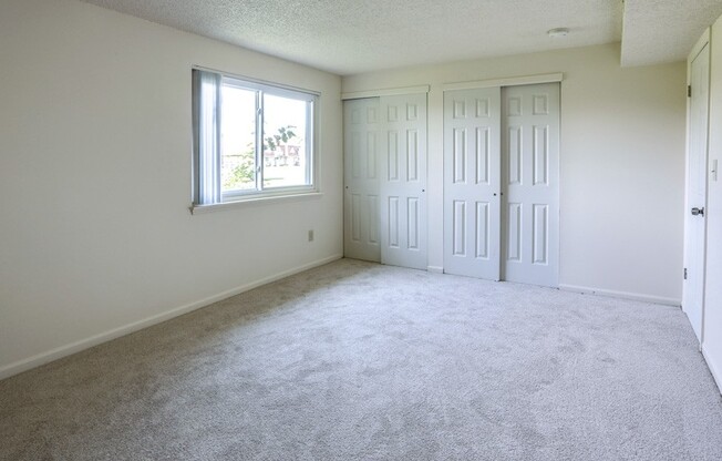 an empty living room with two doors and a window