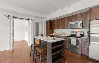 A kitchen with a white fridge, stove, and microwave.