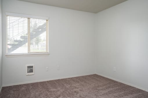 an empty room with carpet and a window