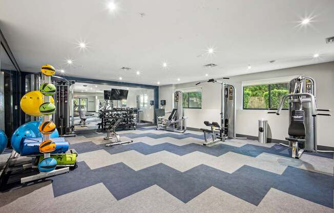 A gym with a variety of equipment including treadmills, weights, and exercise machines.