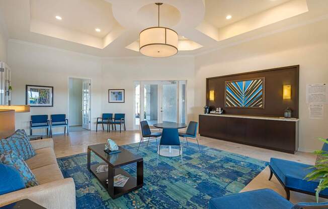 A living room with a blue rug and a white sofa.