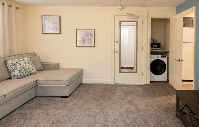 a living room with a couch and a washing machine