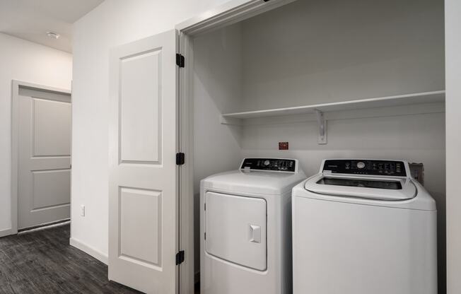 a white washer and dryer in a laundry room with white doors