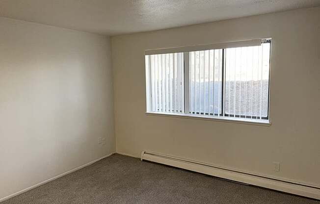 A garden style living room with a window and a carpeted floor at Waverly Park Apartments, Lansing