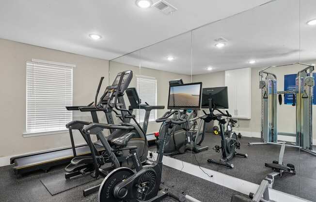 A gym with treadmills, exercise bikes, and other equipment.