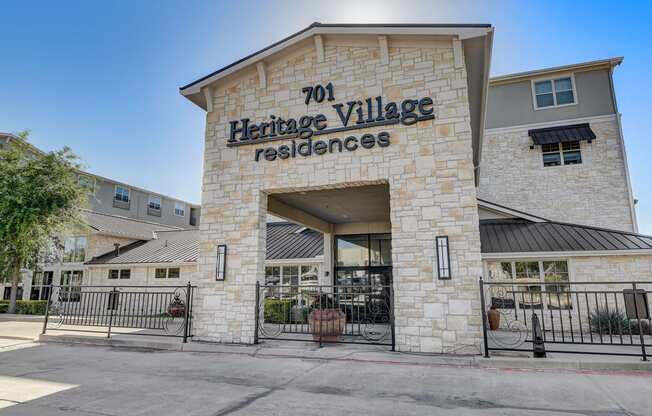 the facade of heritage village residences with a gate