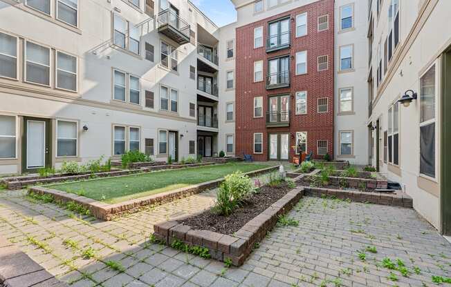 A courtyard with a brick wall and a small garden.
