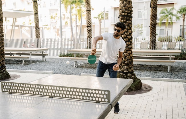 Man playing ping pong at LandonHouse Apartments