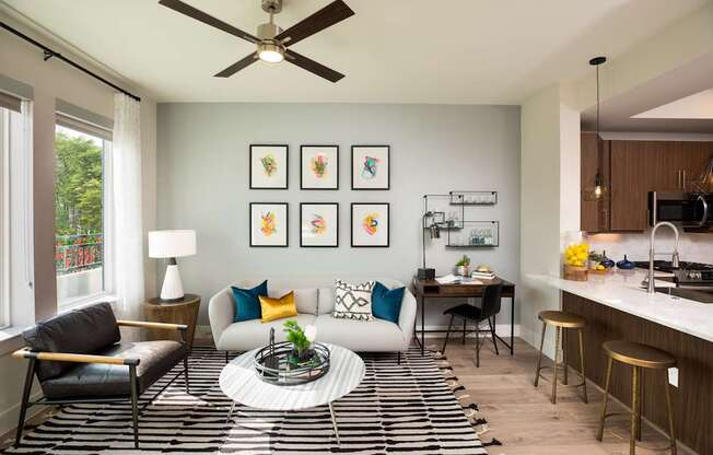 A living room with a black and white striped rug and a ceiling fan.