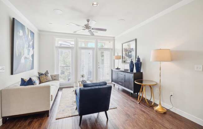 a living room with a couch and a chair and a ceiling fan