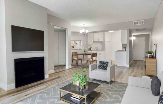 a living room with a fireplace and a kitchen in the background