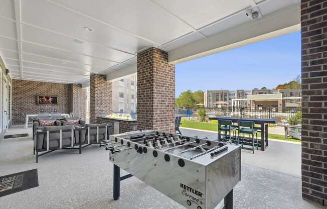 A Kettler outdoor grill is in the foreground of a patio area.