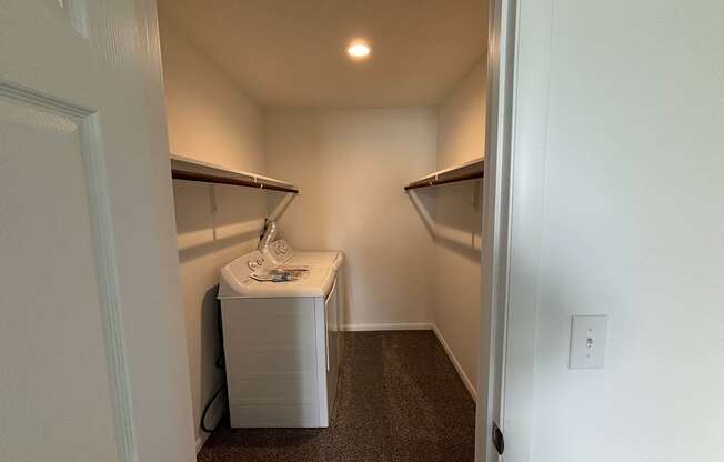 a walk in closet with a sink and a dryer