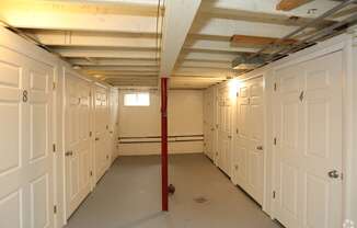 a large room with many white doors and a red pole