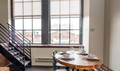 a dining room with a table and chairs in front of a window