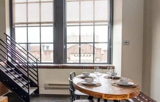 a dining room with a table and chairs in front of a window