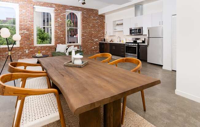a dining room and kitchen with a wooden table and chairs