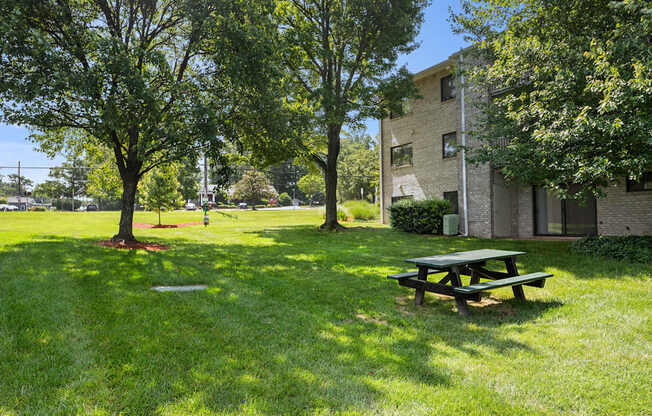 a picnic table in the grass in front of a building