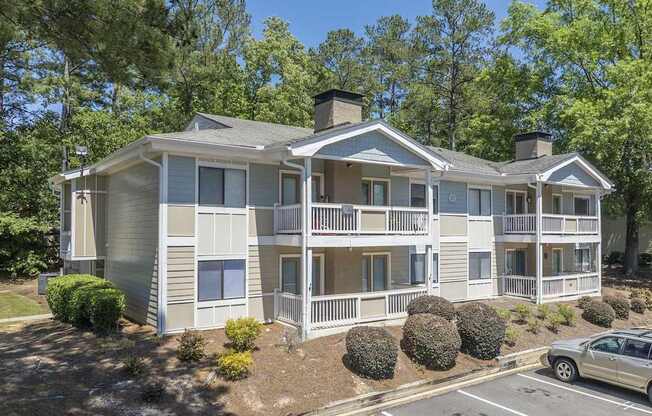 A two-story apartment building with a car parked in front.