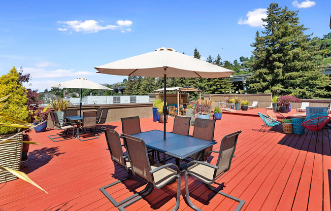 Rooftop wooden deck with tables and umbrellas at Illumina Apartment Homes, Seattle, Washington 98102