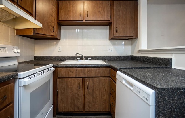 a kitchen with white appliances and brown cabinets