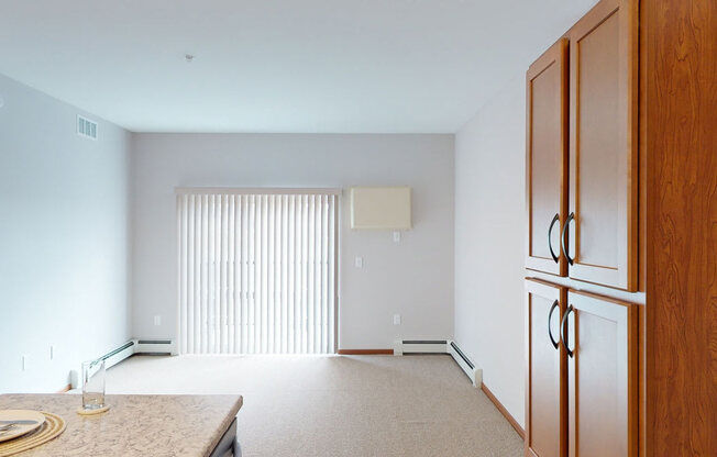 a kitchen and living room with a refrigerator and a table