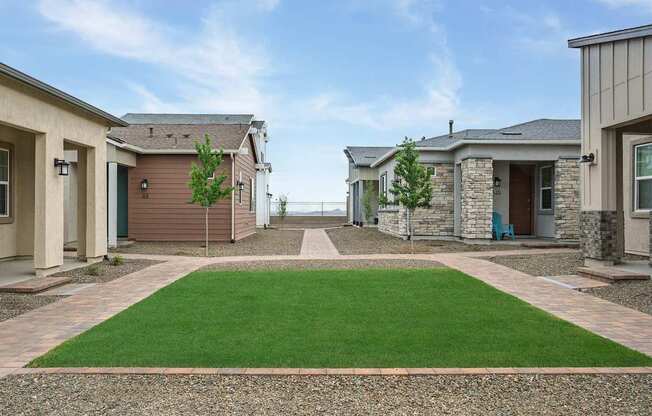 A row of houses with a green lawn in the foreground.