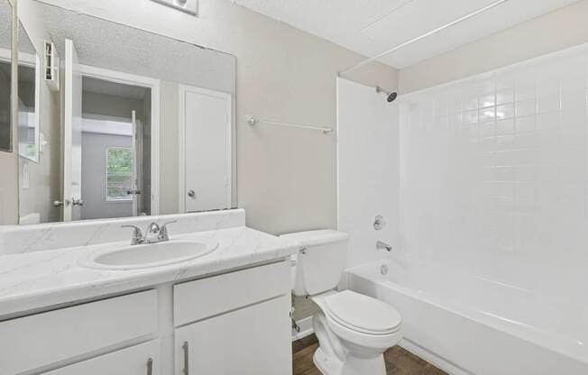 A white bathroom with a toilet, sink, and bathtub.