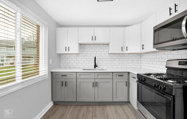 a kitchen with white cabinets and a black stove