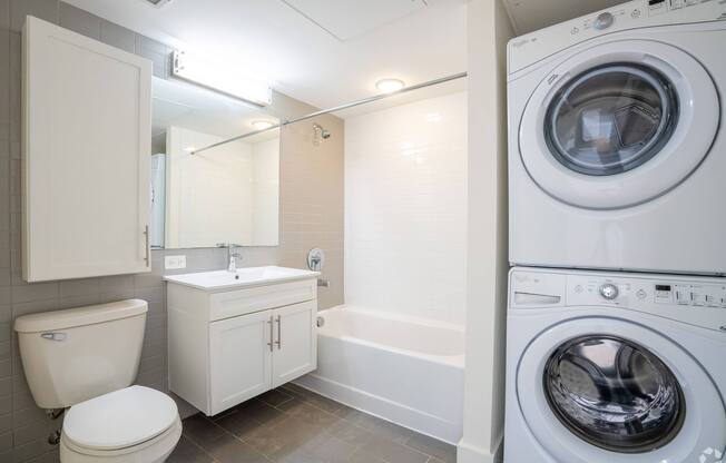 A white bathroom with a washing machine in the corner at 603 Concord Apartments, Massachusetts